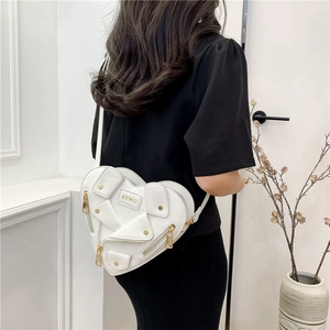 White heart-shaped crossbody bag with motorcycle jacket details shown on a model