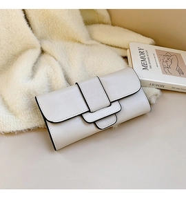 Detail of minimalist beige faux leather clutch with black edges and layered flap design