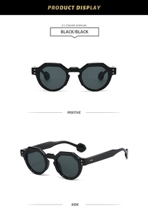 Close-up of black irregular hexagonal sunglasses showing front and thick side temple views
