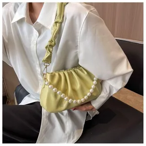 Detail of avocado green ruched cloud bag featuring decorative pearl chain and soft texture