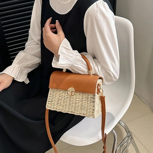 Woven straw crossbody bag with brown leather flap and gold metal clasp in elegant style