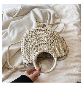 Détail du sac à main en paille tressée avec poignées rondes et doublure à pois