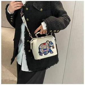 Détail du sac docteur blanc avec broderie d'éléphant et large bandoulière à motifs