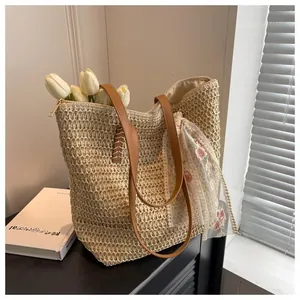 Detail of straw woven tote bag with lace floral scarf and premium leather handles