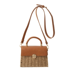 Woven straw and brown leather shoulder bag with gold metal clasp on white background