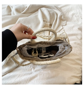 Vue de dessus du sac en paille tressée montrant la doublure à pois et l'espace de rangement