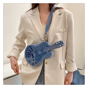 Detailed view of guitar-shaped denim crossbody bag with metal rivets and shoulder strap