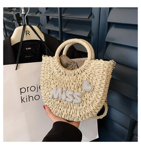 Détail du sac en paille avec texte Miss en perles et doublure à pois à cordon