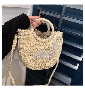 Détail du sac en paille avec lettres MISS en perles et doublure à pois marron