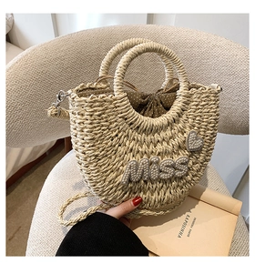 Détail du sac en paille fait main avec lettrage en perles et doublure à pois marron