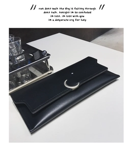 Détail du portefeuille en cuir noir avec boucle argentée en forme de lune et d'étoile