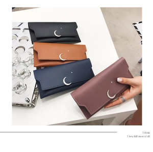 Détail de portefeuilles longs en cuir avec breloques lune et étoile en quatre couleurs