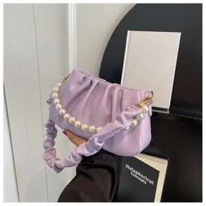 Close-up of light purple pleated cloud bag with elegant pearl handle and PU leather texture