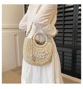 Détail du sac en paille fait main avec lettrage en perles Miss et pochette intérieure à pois