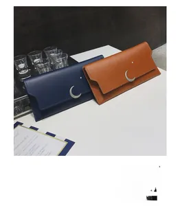 Détail de portefeuilles longs avec fermoir lune et étoile en bleu marine et marron