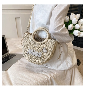 Détail du sac demi-lune en paille crème avec texte Miss en strass et cordon de serrage