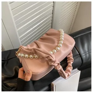 Detail of pink ruched cloud bag featuring decorative pearl beads and soft leather pleats