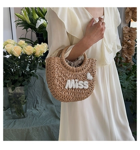 Détail du sac en paille avec lettrage Miss en perles et doublure à pois marrons