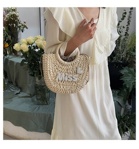 Détail du sac en paille tissé avec lettres en perles MISS et forme coquillage de plage