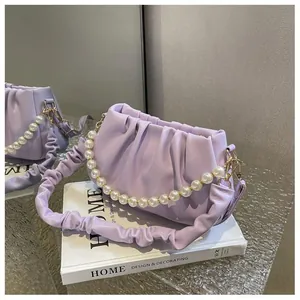 Close-up of lilac ruched cloud bag with large pearl handle and soft leather folds