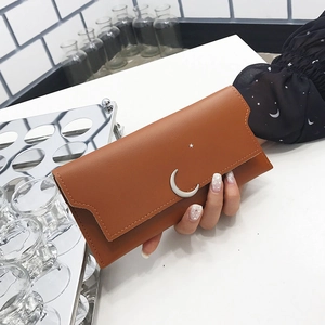 Portefeuille long femme couleur caramel avec pendentifs lune et étoile en main