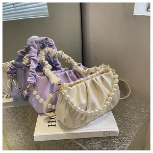 Detail of beaded cloud bags in light purple and off-white with soft pleated leather finish