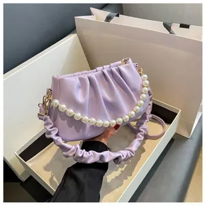 Detail view of lavender ruched cloud bag with large pearl bead chain on gift box