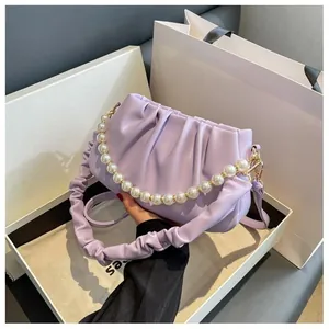 Detailed macro view of light purple pleated cloud bag with elegant large pearl handle chain