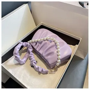 Detail of light purple pleated cloud bag with pearl chain and fabric strap in gift box