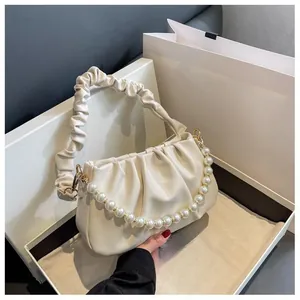 Close-up of beige pleated cloud bag featuring premium faux leather and large pearl chain