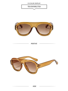 Detail view of retro oversized tea gradient lenses and wide amber frames with side hinge