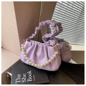 Detail of lavender pleated cloud bag featuring large pearls and soft leather texture