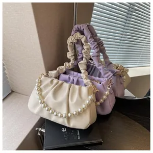 Detail view of cloud-shaped pleated bags with pearl chains and soft PU texture