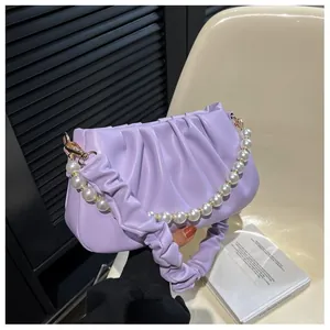 Close-up of lilac ruched cloud bag with decorative pearl handle and fabric strap