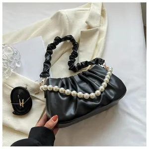 Detail of black pleated cloud bag with pearl handle and versatile strap options