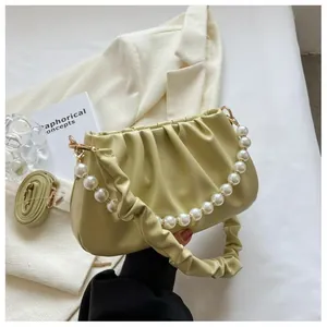 Detail of pistachio green pleated cloud bag with pearl handle and leather straps