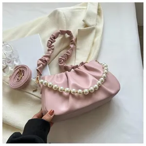Pink pleated leather cloud bag detail featuring elegant pearl chain and strap