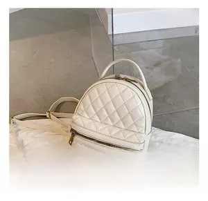 Dettaglio dello zaino trapuntato beige con cerniere in metallo dorato lucido