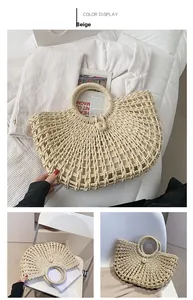 Detail of hand-woven beige straw tote bag with intricate hollow mesh and circular handles
