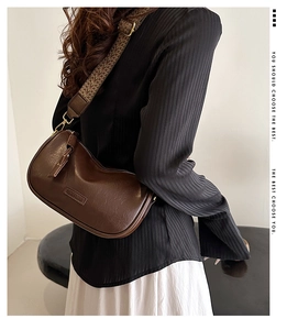 Gros plan du sac bandoulière rétro en cuir PU marron avec large bandoulière tissée et finitions or
