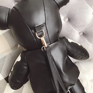 Close-up of bear backpack back featuring lychee leather texture and gold metal D-rings