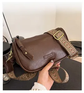 Détail du sac bandoulière marron foncé avec large bandoulière tissée de style ethnique