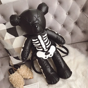 Macro detail of black leather bear backpack with white skeleton print and stitched eyes