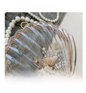 Détails d'un sac transparent en forme de coquillage avec perles et étoiles de mer