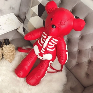Detailed view of red bear leather backpack with white bone print and cross stitch details