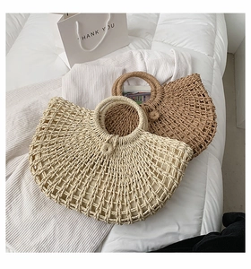 Detail of handmade hollow straw woven handbags in beige and dark coffee colors