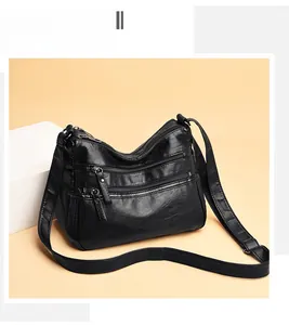 Detail shot of black washed leather crossbody bag showing four zippered pockets and texture