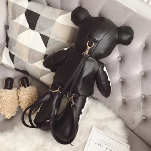 Detail of bear-shaped leather backpack featuring white bone patterns and metal zipper