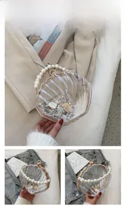 Détail du sac en acrylique en forme de coquille avec anse en perles blanches et perles internes