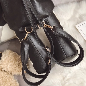 Close-up of black pebbled leather backpack straps with high-quality gold metal hardware